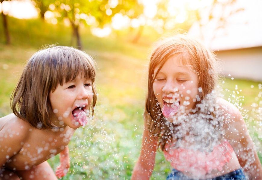 children playing in sprinkler