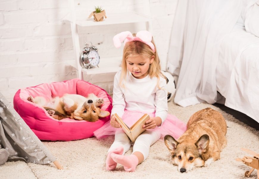 girl reading to dogs in bedroom