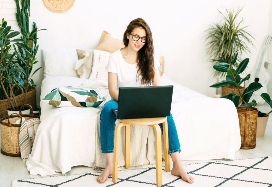 woman in bedroom using laptop