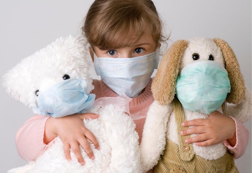 masked child with stuffed toys