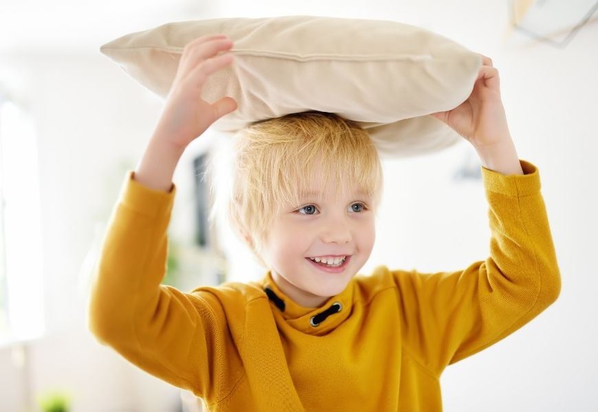 boy holding pillow on his head